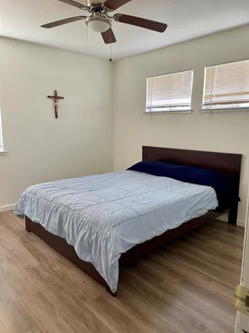 a bedroom with a bed and a ceiling fan