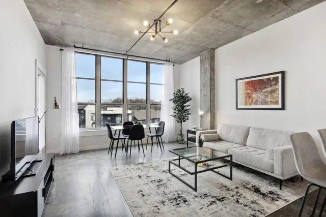 a living room with furniture wooden floor and a flat screen tv