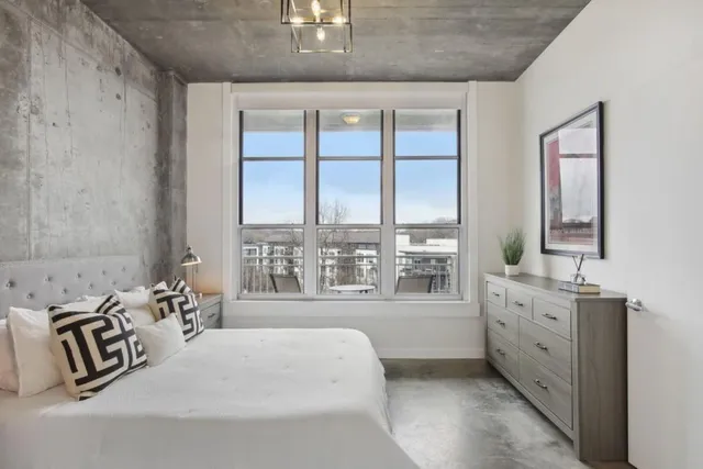 a bedroom with a bed next to a large window