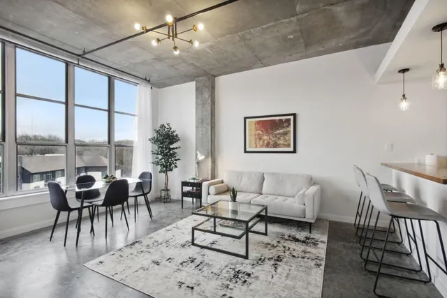 a living room with furniture and floor to ceiling windows
