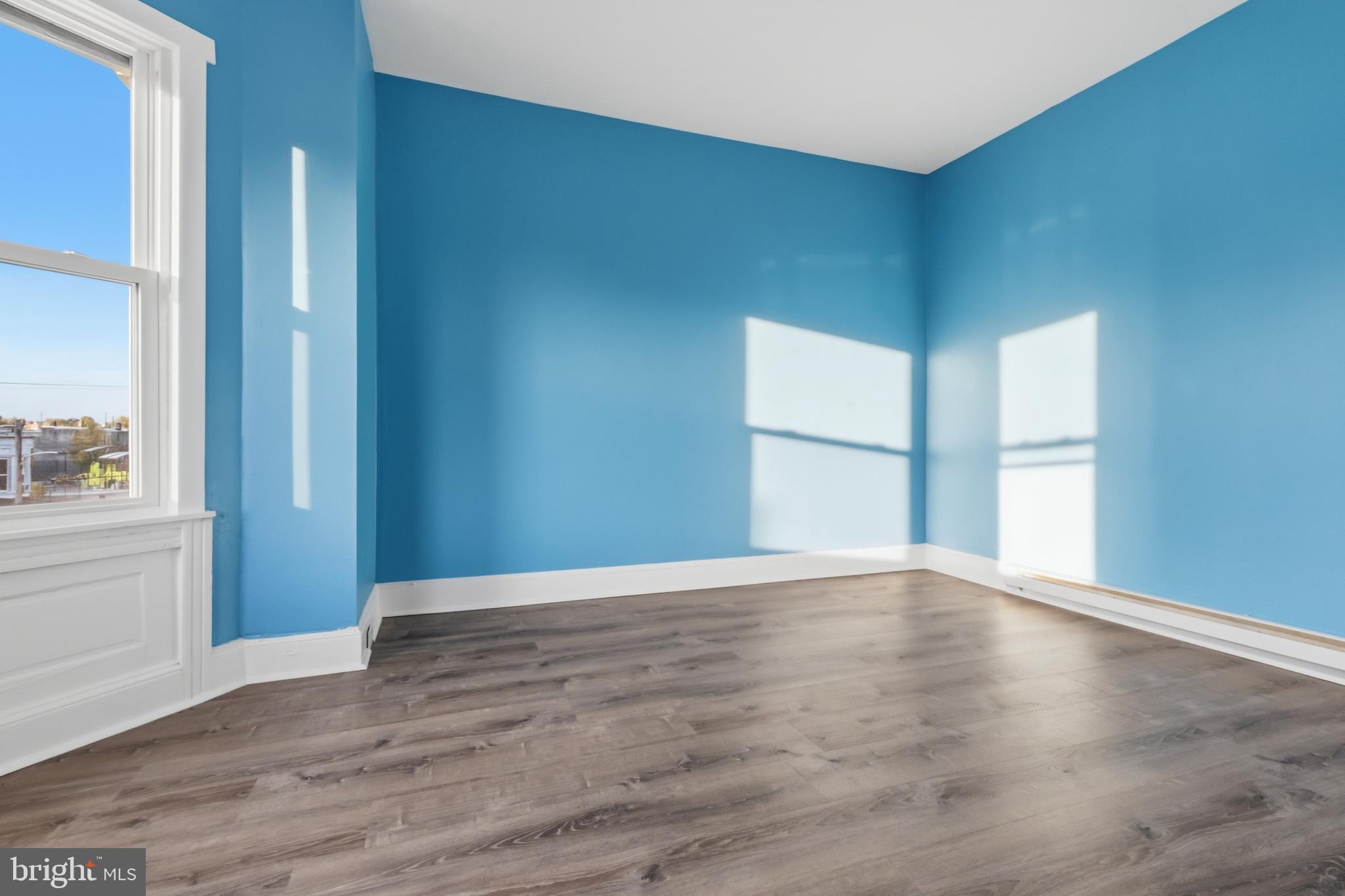 3545 North 11th Street, Unit 3 Philadelphia, PA 19140 - Photo 11 of 11 a view of an empty room with wooden floor and a window