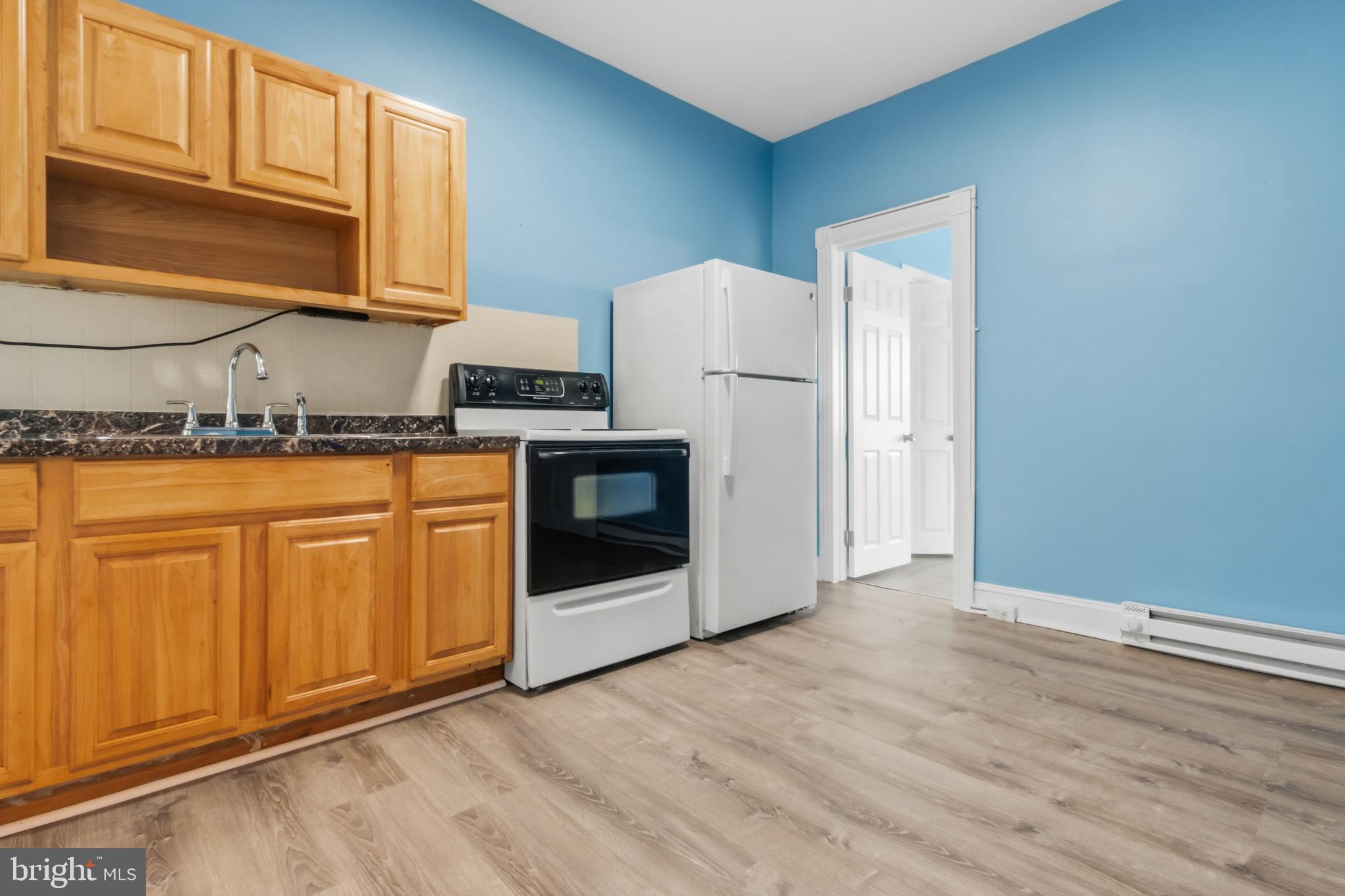 3545 North 11th Street, Unit 3 Philadelphia, PA 19140 - Photo 2 of 11 a kitchen with granite countertop cabinets stainless steel appliances and wooden floor