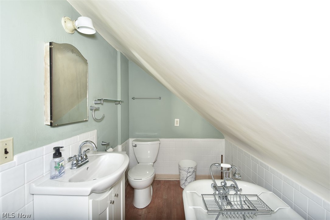 2559 Channing Road Cleveland, OH 44118 - Photo 22 of 28 Bathroom featuring vanity, hardwood / wood-style flooring, tile walls, vaulted ceiling, and toilet