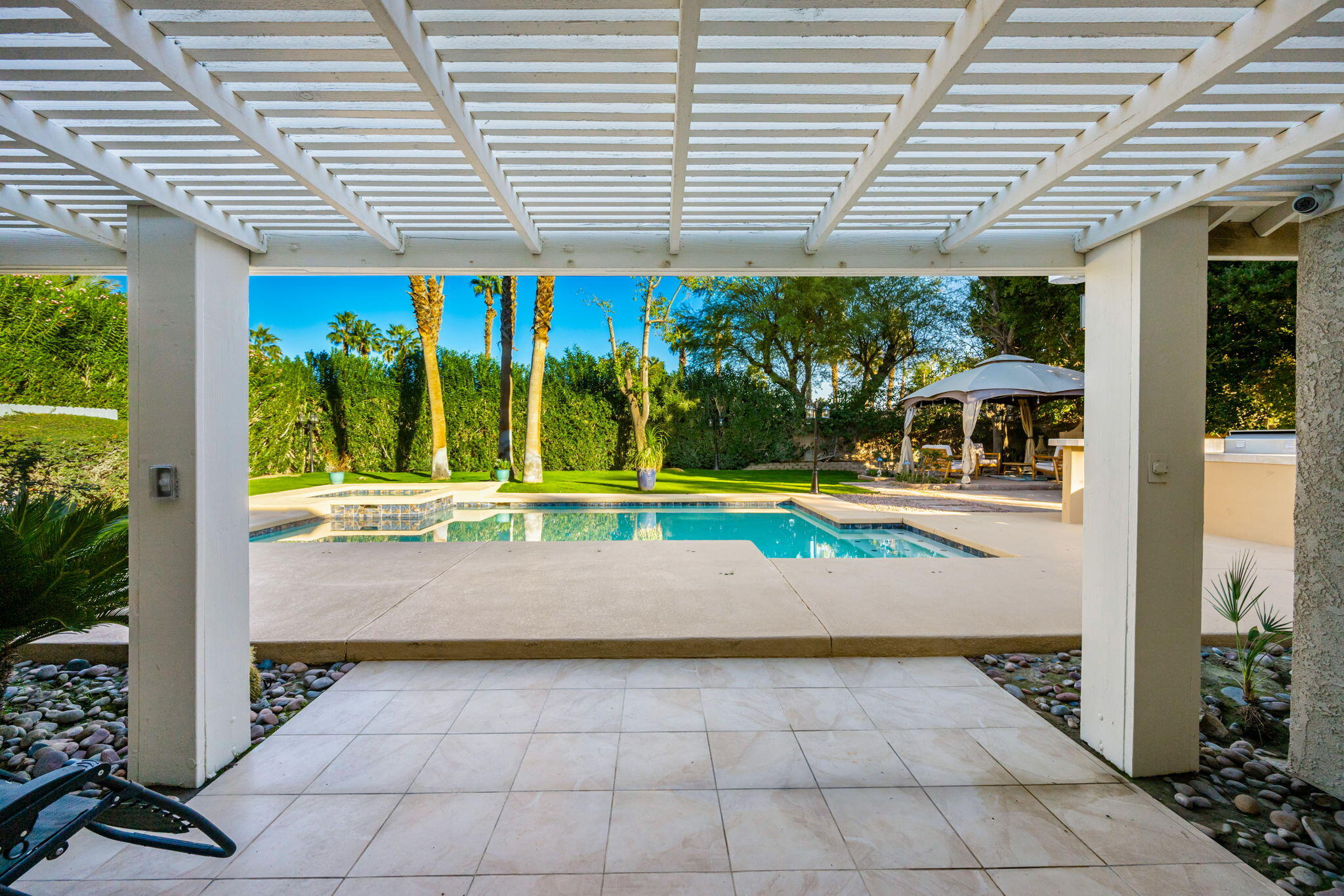 39790 Regency Way Palm Desert, CA 92211 - Photo 28 of 59 a view of a patio with a table and chairs next to a yard