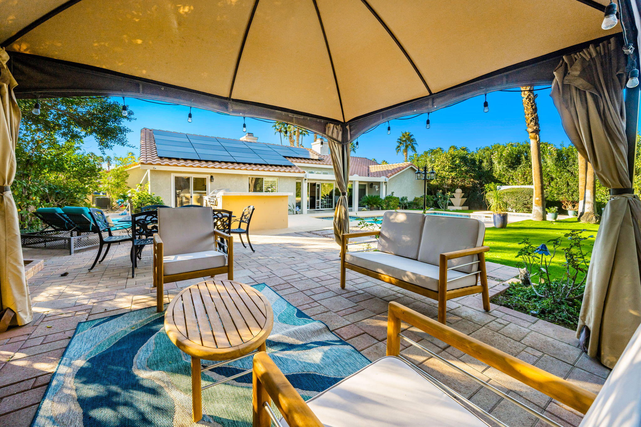 39790 Regency Way Palm Desert, CA 92211 - Photo 36 of 59 a view of a patio with table and chairs potted plants and floor to ceiling window