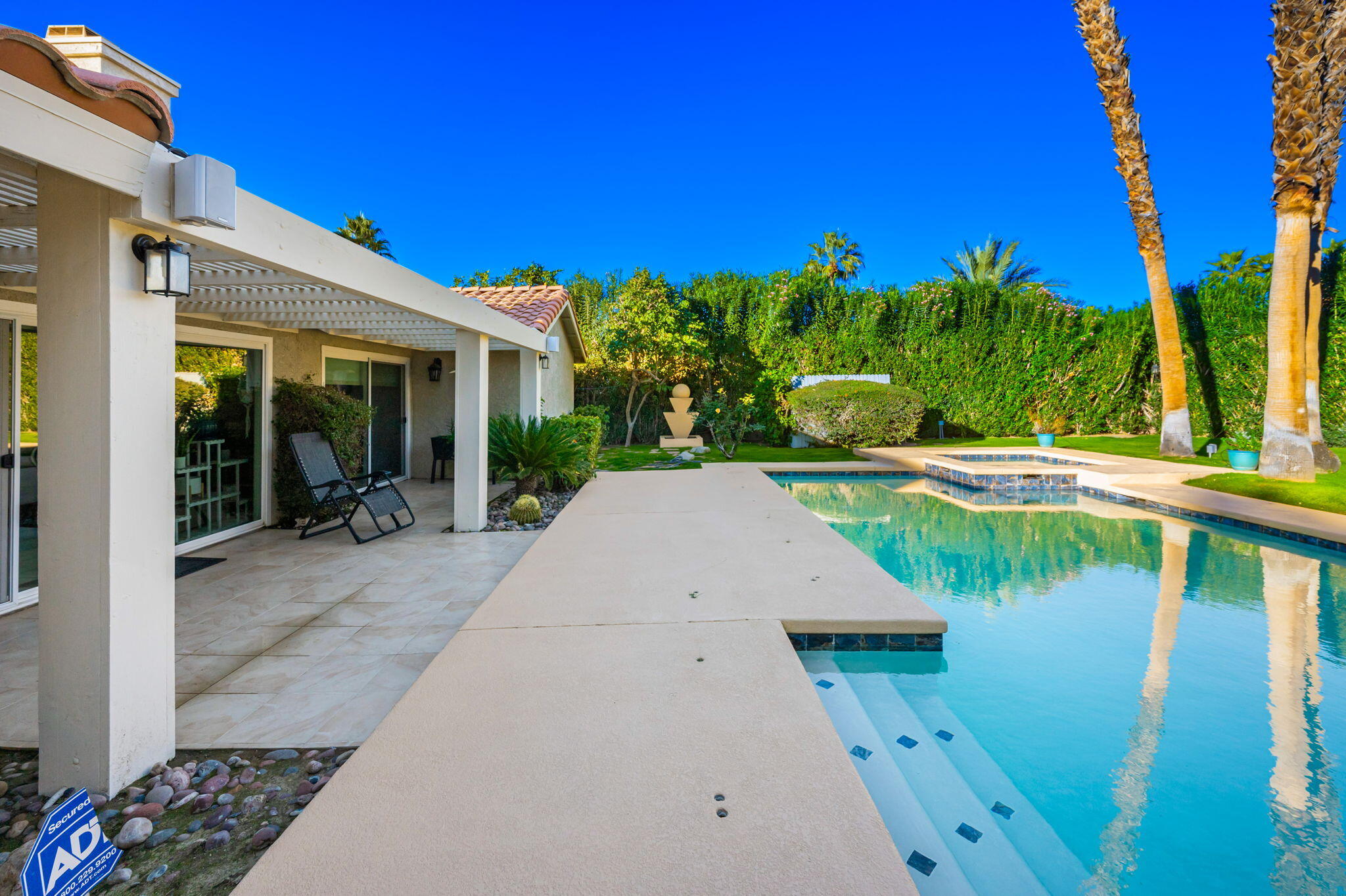 39790 Regency Way Palm Desert, CA 92211 - Photo 40 of 59 a view of a swimming pool with lawn chairs and plants