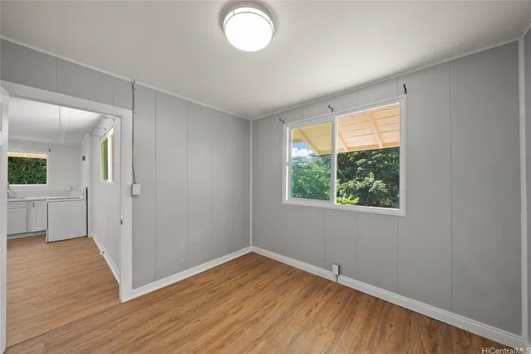 a view of empty room with wooden floor and fan