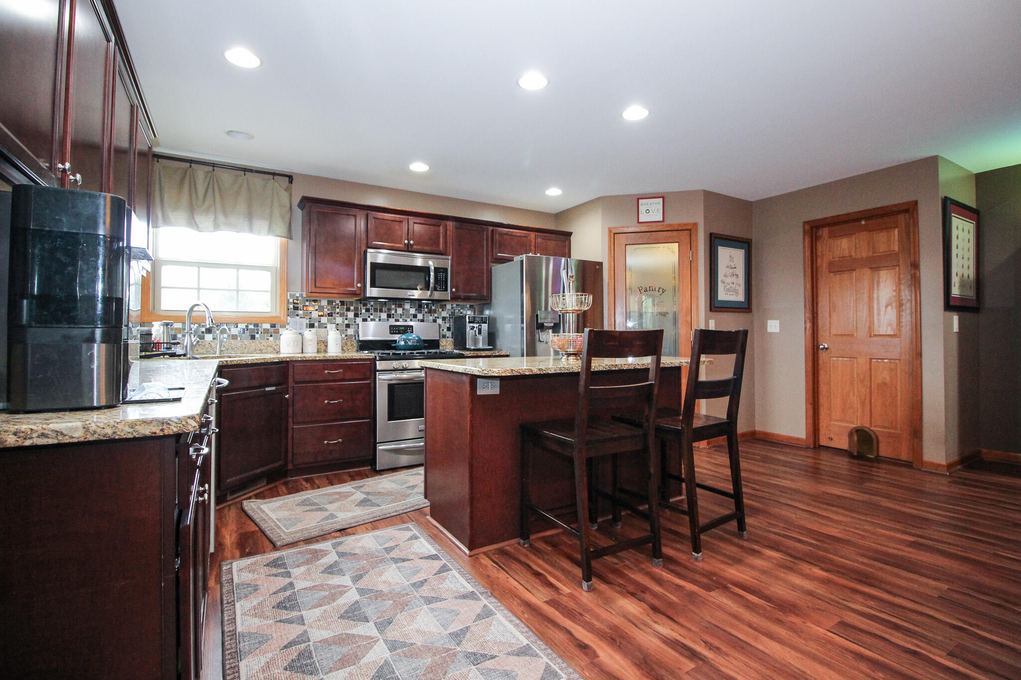 2913 Cardinal Drive Wheatfield, IN 46392 - Photo 11 of 34 a kitchen with stainless steel appliances granite countertop a table chairs sink and cabinets