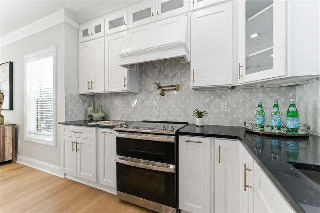 a kitchen with stainless steel appliances granite countertop white cabinets sink and stove