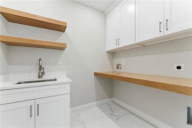 a view of cabinets and utility room with two washing machine