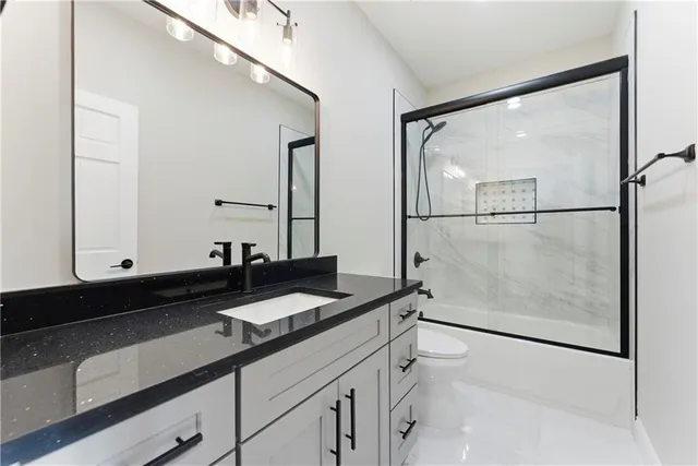 a bathroom with a granite countertop sink a mirror and a shower