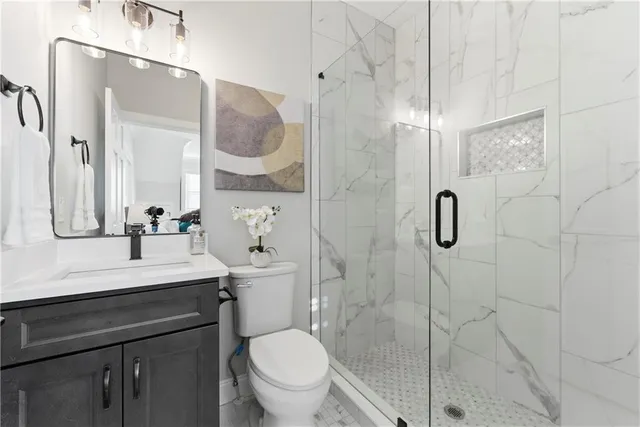 a bathroom with a sink toilet a mirror and shower