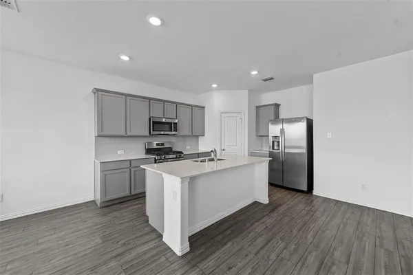 a kitchen with stainless steel appliances a sink stove refrigerator and cabinets