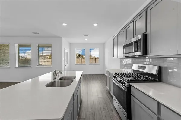 a kitchen that has a sink and a stove top oven