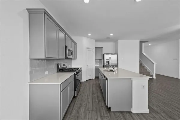 a kitchen with stainless steel appliances granite countertop a sink stove and refrigerator