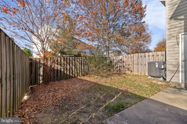 a view of a yard with wooden fence