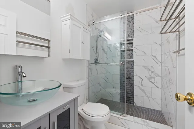 a bathroom with a sink a toilet and shower