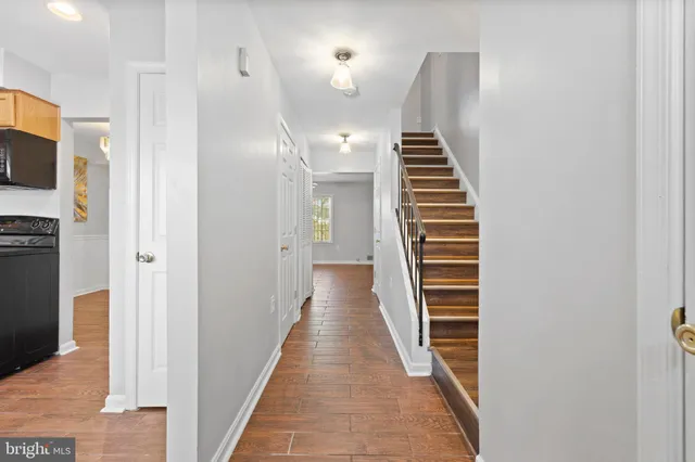 a view of a hallway with wooden floor and entryway