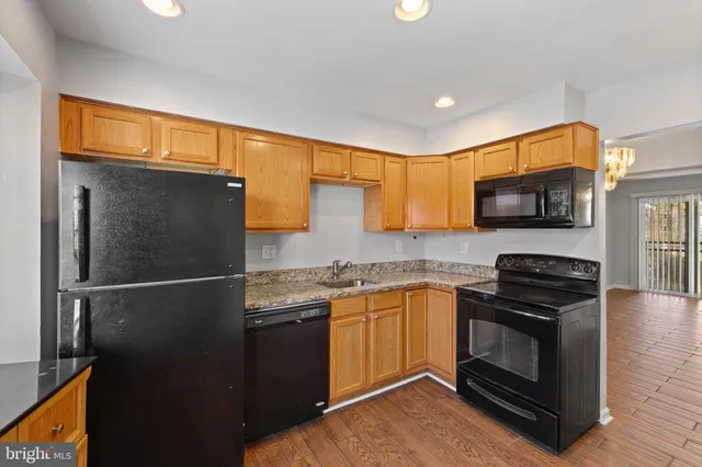 a kitchen with granite countertop a sink stove and refrigerator