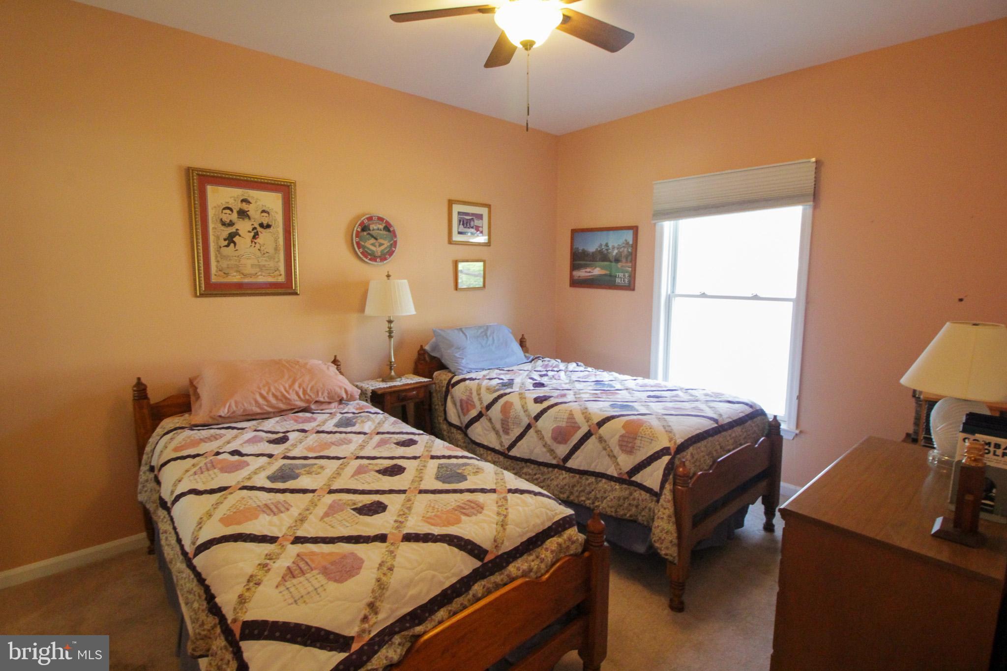 32464 Approach Way, Unit 3278 Millsboro, DE 19966 - Photo 12 of 47 a bedroom with two beds and a chandelier