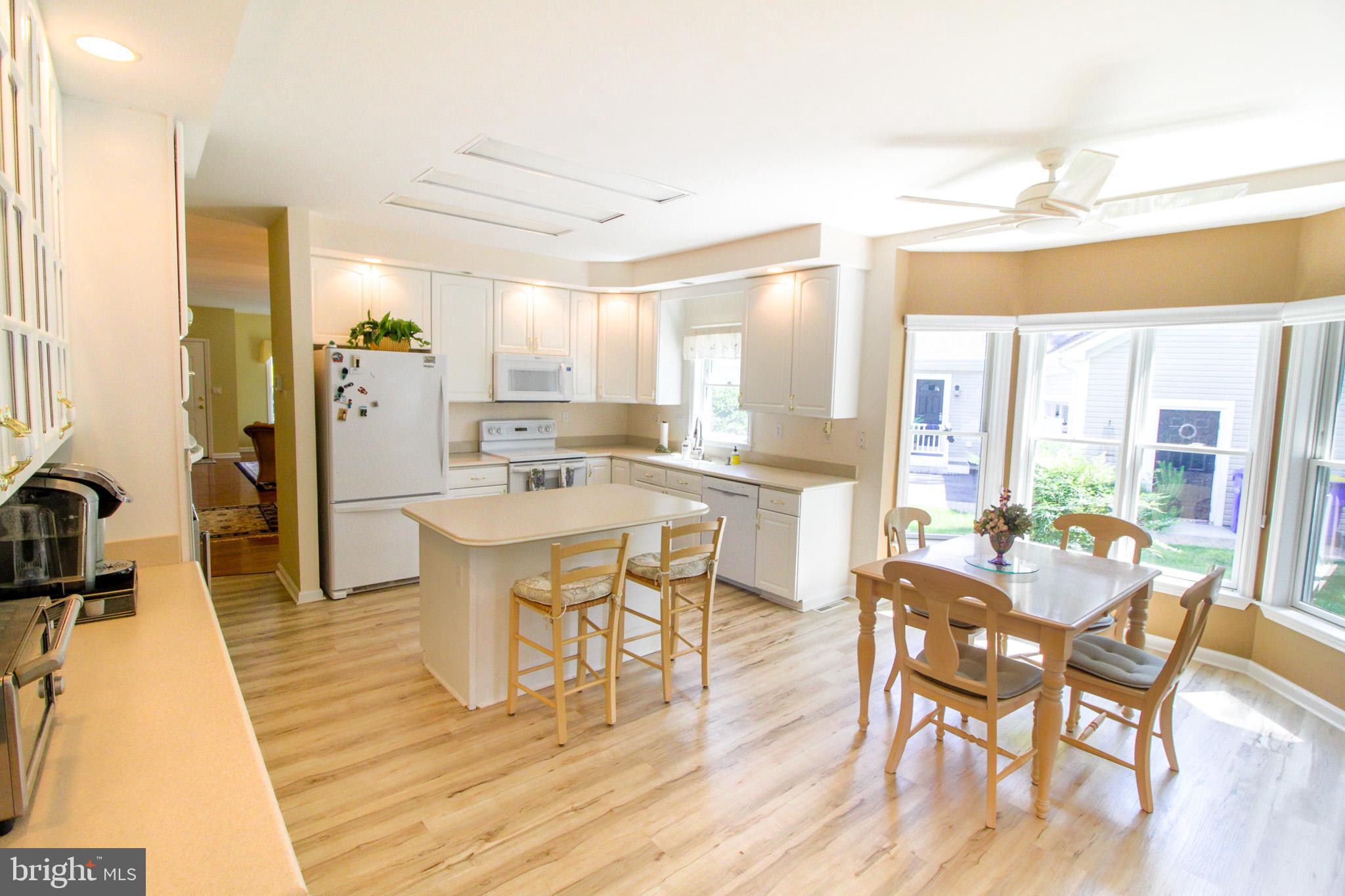 32464 Approach Way, Unit 3278 Millsboro, DE 19966 - Photo 24 of 47 a dining hall with stainless steel appliances a dining table wooden floor and a large window