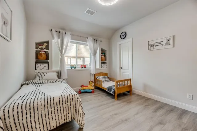 a bedroom with a bed and wooden floor