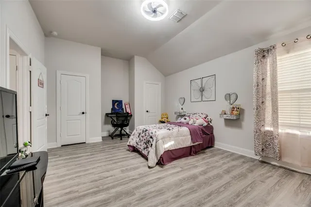 a bedroom with a bed and wooden floor