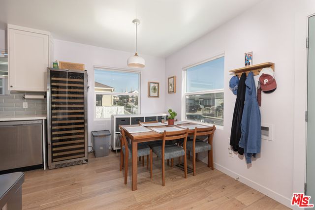 a view of a dining room and livingroom with furniture wooden floor a rug a rug a fireplace and a chandelier