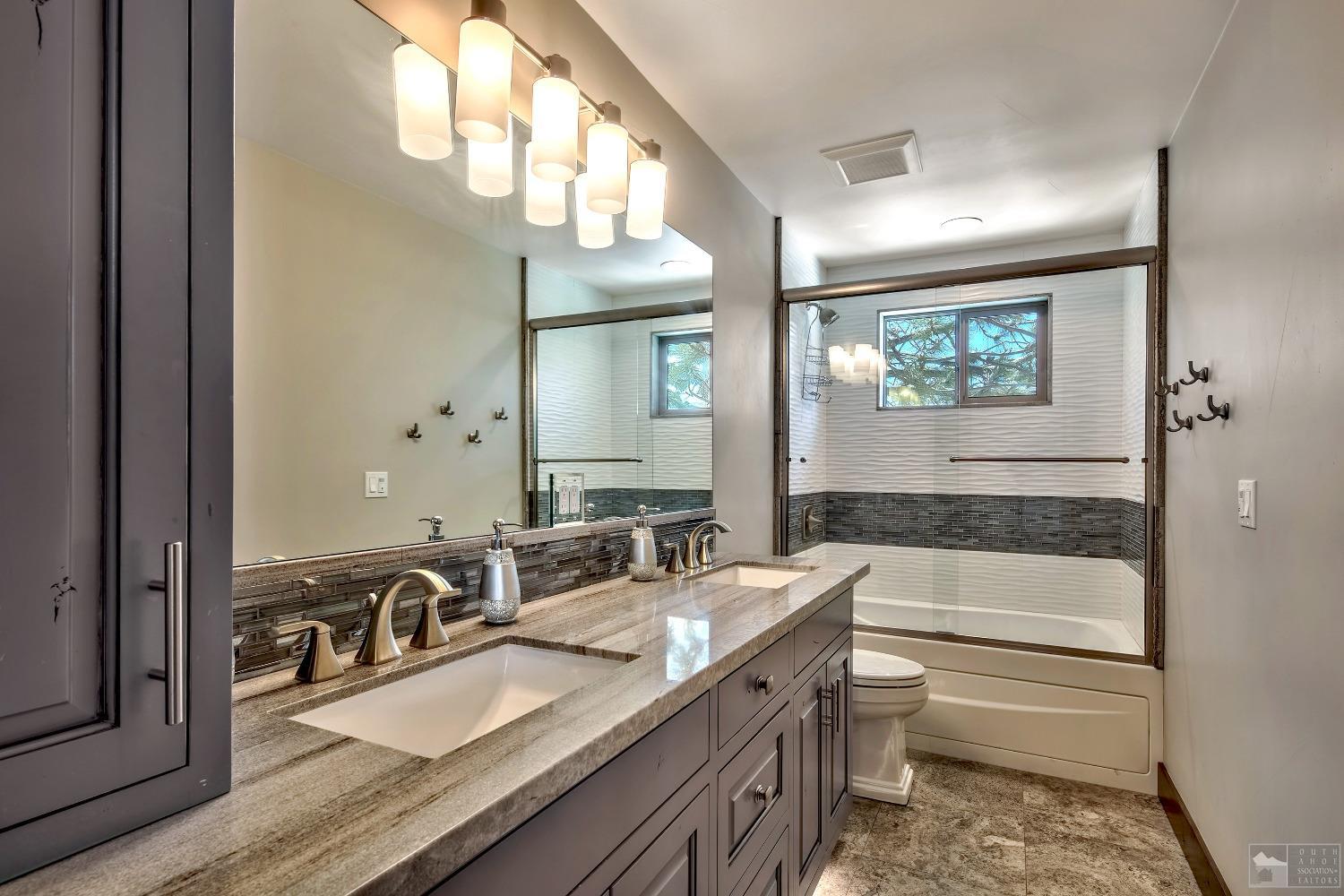 416 Maryanne Drive Stateline, NV 89449 - Photo 12 of 32 a bathroom with a granite countertop sink a toilet a mirror and bathtub