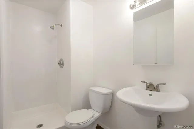 a white toilet sitting next to a bathroom sink