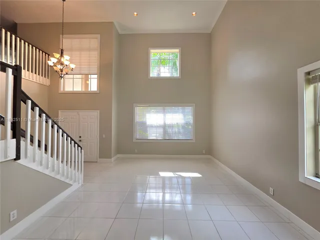 an empty room with windows and chandelier