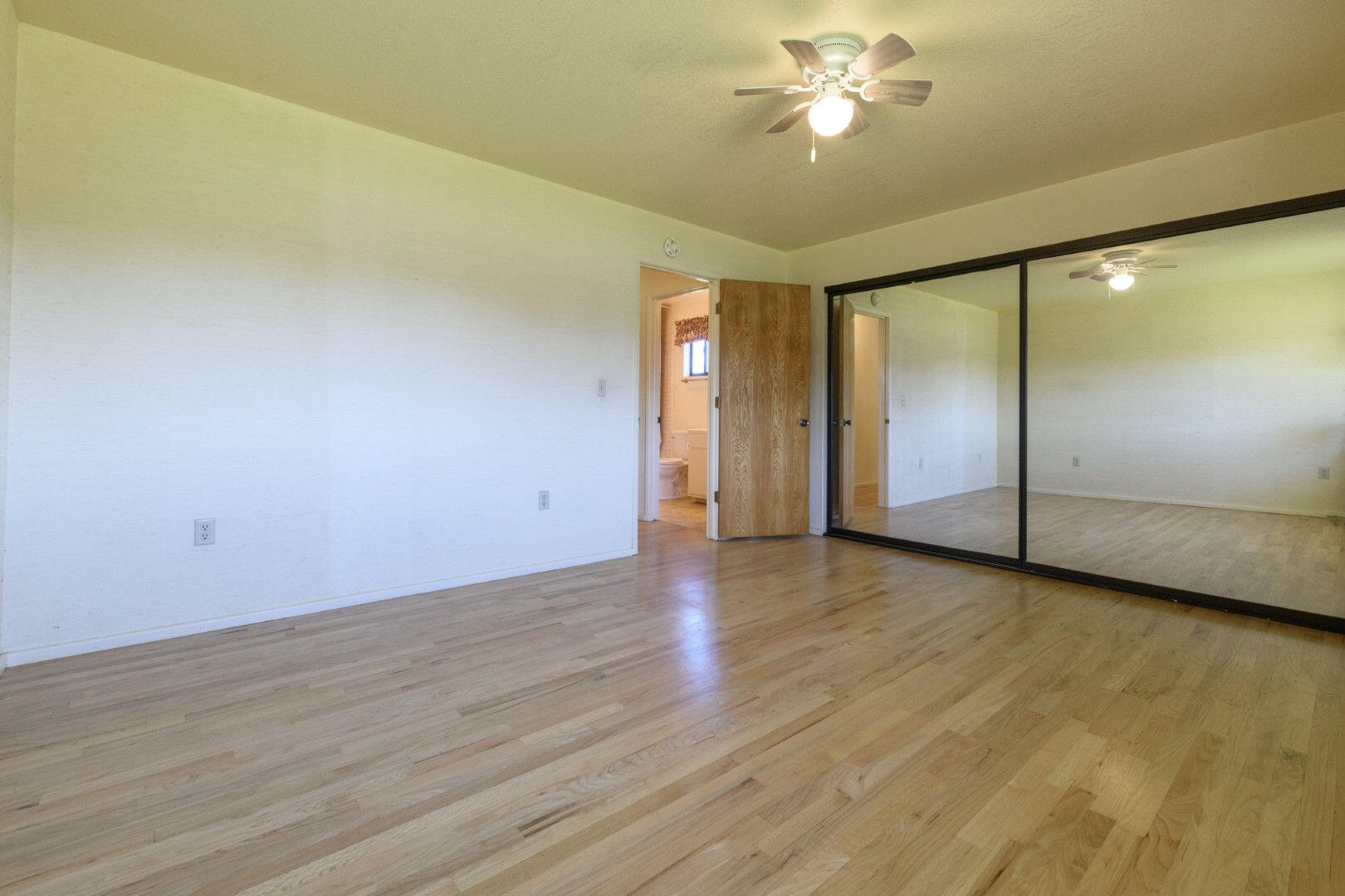7035 Riverside Drive Redding, CA 96001 - Photo 11 of 23 an empty room with wooden floor and windows