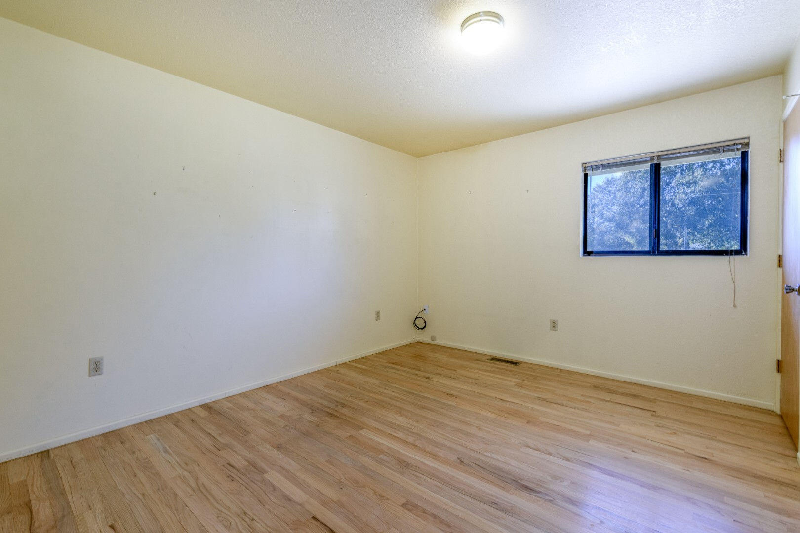 7035 Riverside Drive Redding, CA 96001 - Photo 13 of 23 an empty room with wooden floor and windows