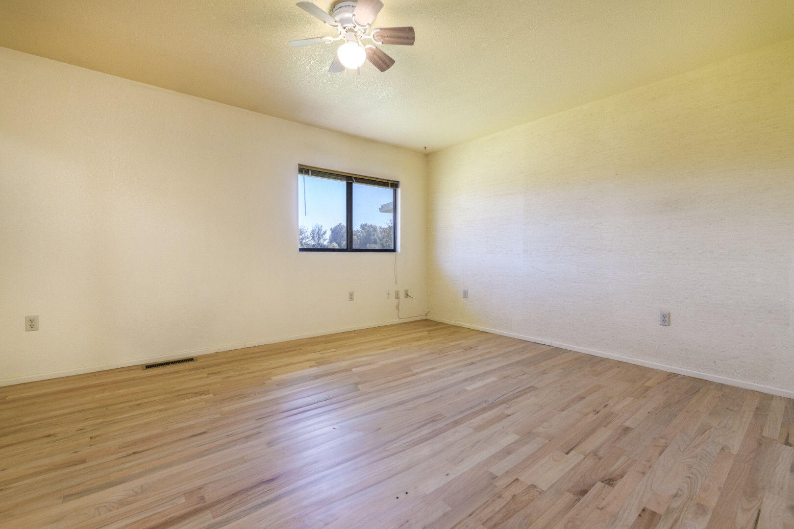 7035 Riverside Drive Redding, CA 96001 - Photo 10 of 23 a view of an empty room with wooden floor and a chandelier fan