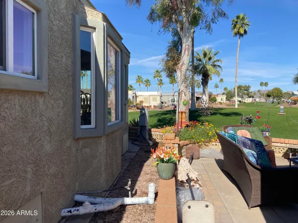 a view of a patio with couches table and chairs potted plants and palm tree