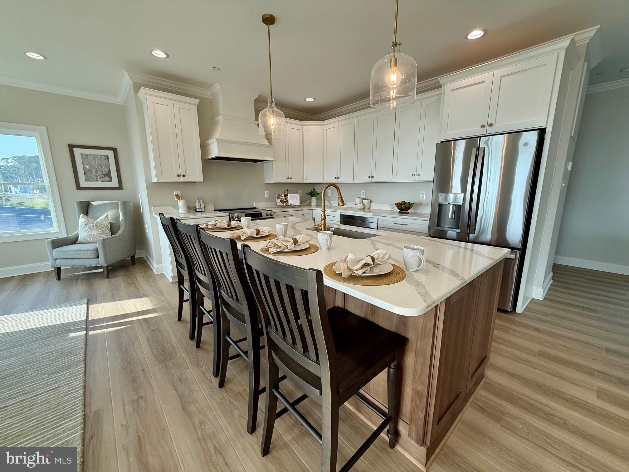 16394 Thomas Road Piney Point, MD 20674 - Photo 17 of 53 a kitchen with stainless steel appliances granite countertop a stove a refrigerator a kitchen island a dining table and chairs with wooden floor