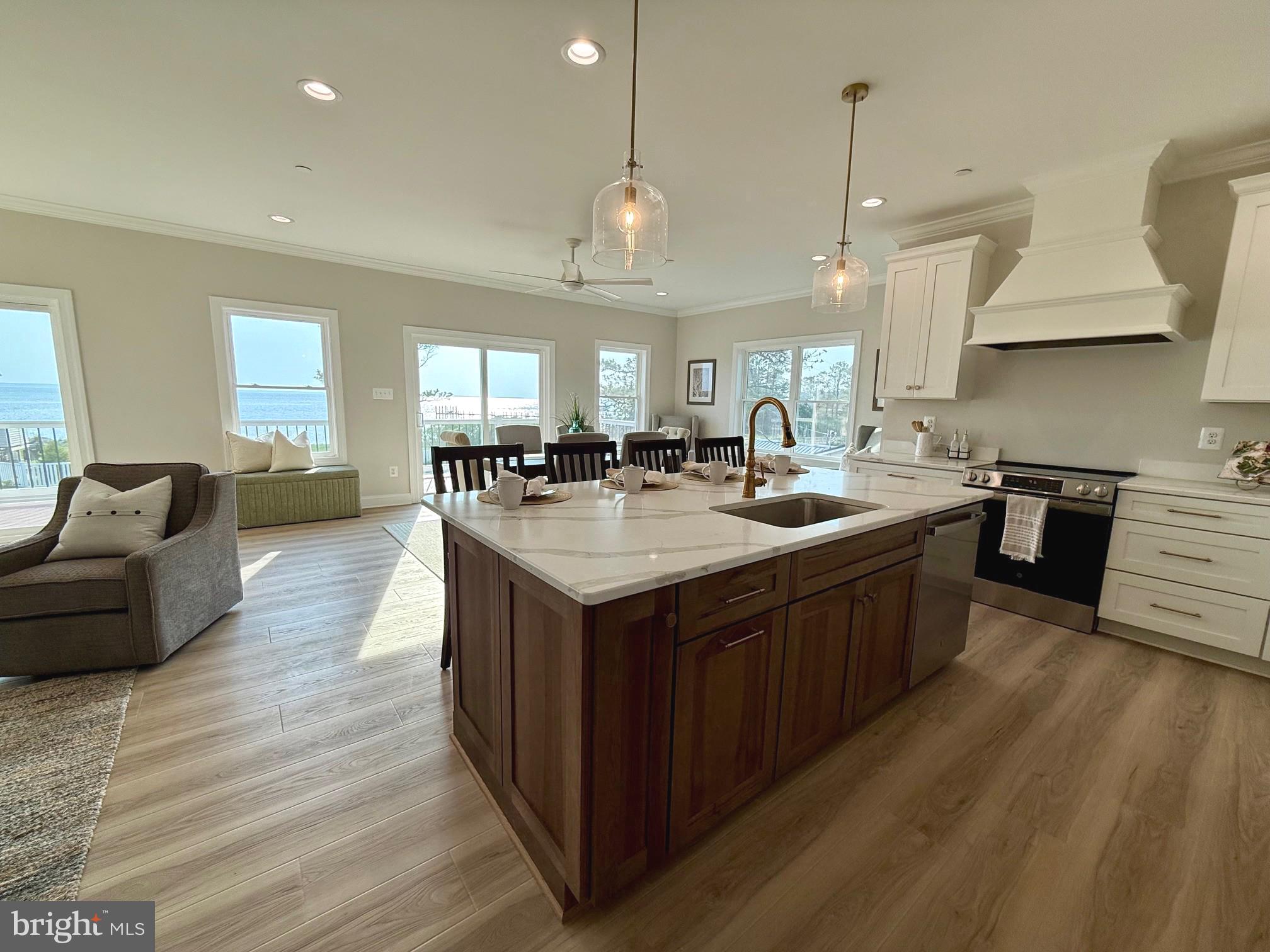 16394 Thomas Road Piney Point, MD 20674 - Photo 23 of 53 a kitchen with a stove a refrigerator a sink dishwasher with a dining table and chairs
