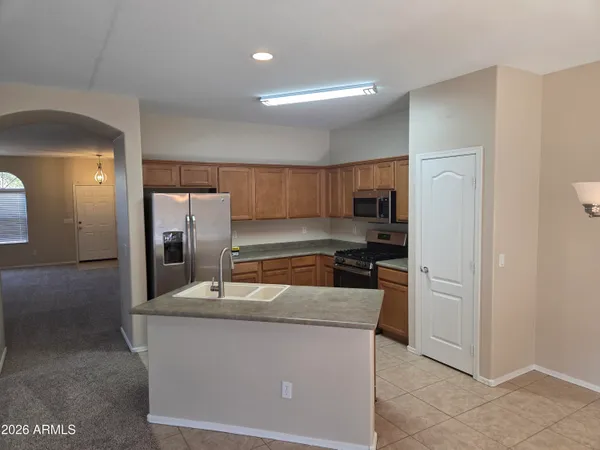 a kitchen with stainless steel appliances granite countertop a refrigerator a stove and a sink