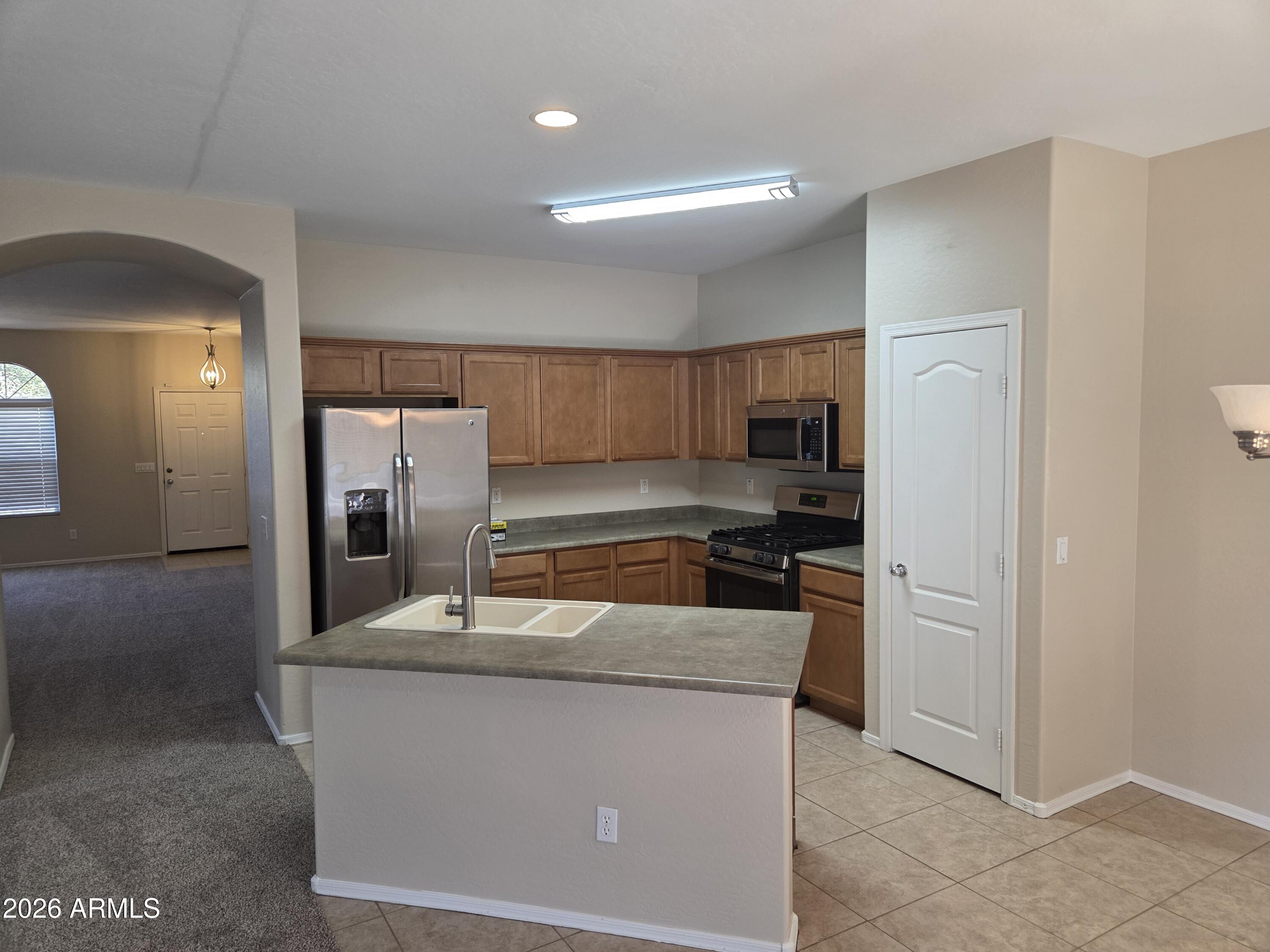 14195 West Hearn Road Surprise, AZ 85379 - Photo 11 of 23 a kitchen with stainless steel appliances granite countertop a refrigerator a stove and a sink