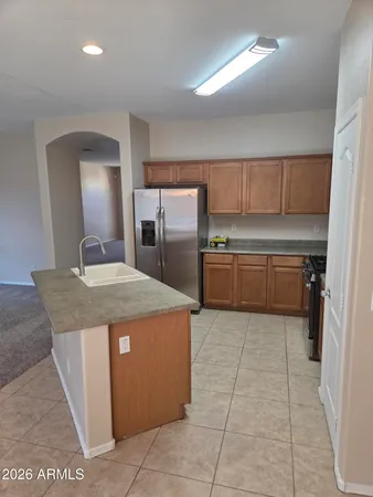a kitchen with kitchen island granite countertop a sink a counter top space and cabinets