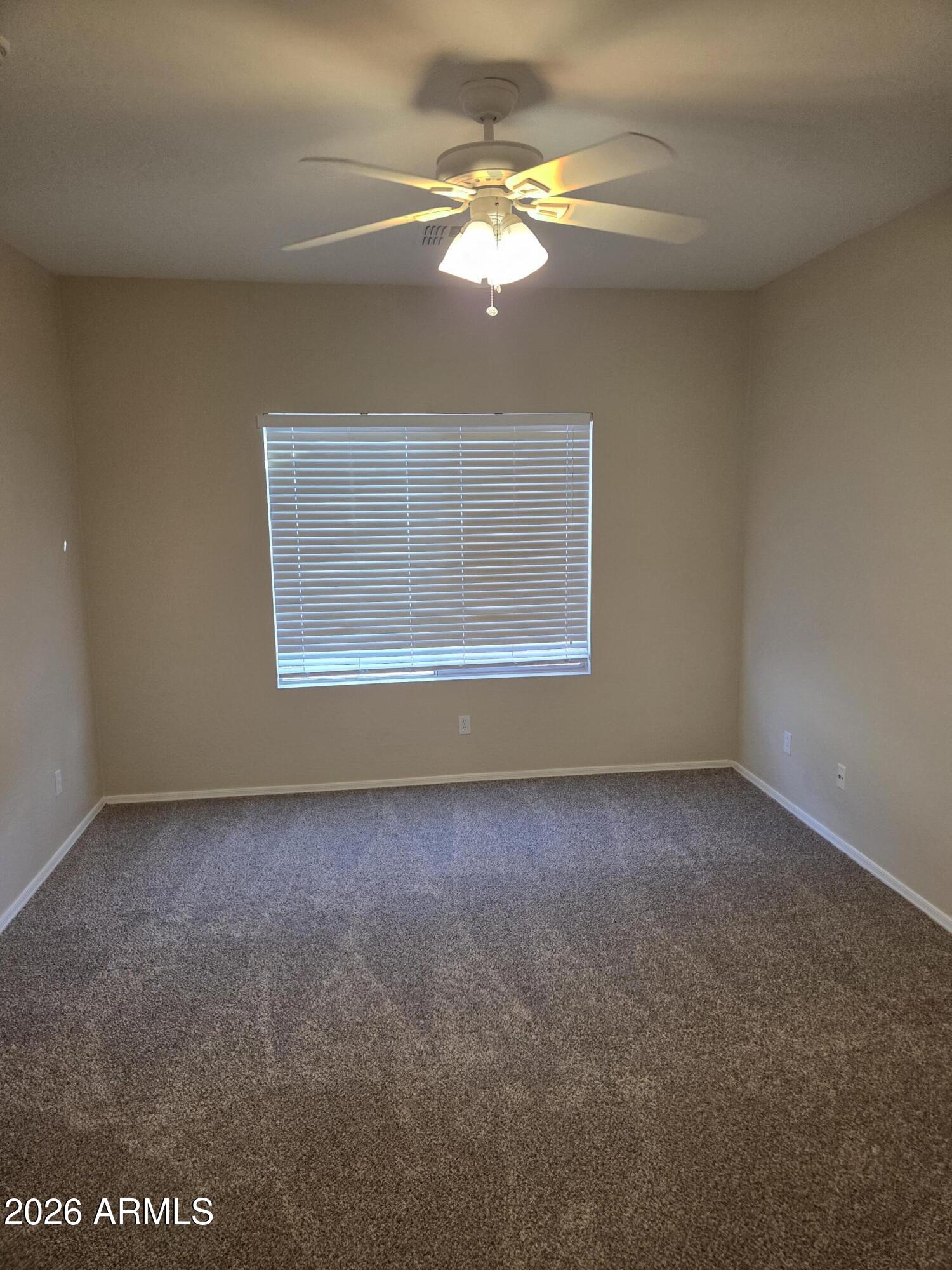 14195 West Hearn Road Surprise, AZ 85379 - Photo 19 of 23 an empty room with a chandelier fan and windows