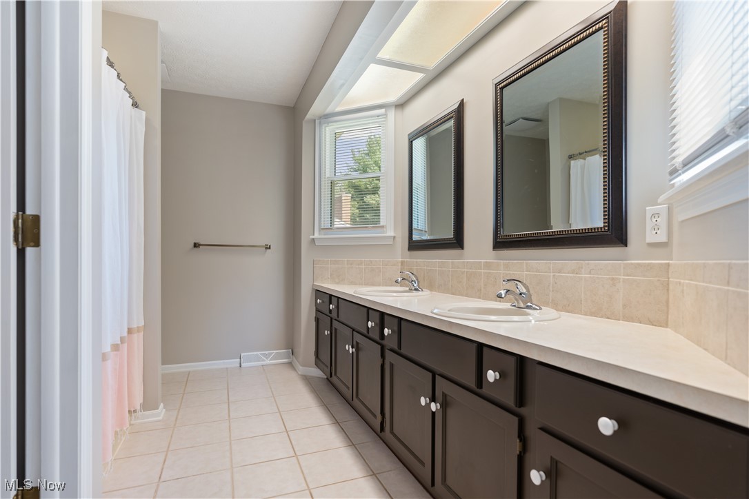 3960 Bramshaw Road Northwest Canton, OH 44718 - Photo 21 of 33 Bathroom with tile patterned flooring, vanity, and decorative backsplash