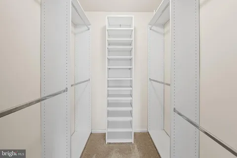 a view of walk in closet with empty racks