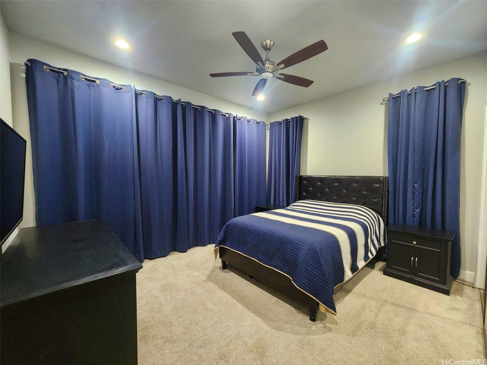 47-285 Waihee Road, Unit D Kaneohe, HI 96744 - Photo 14 of 25 a spacious bedroom with a bed and a cabinets