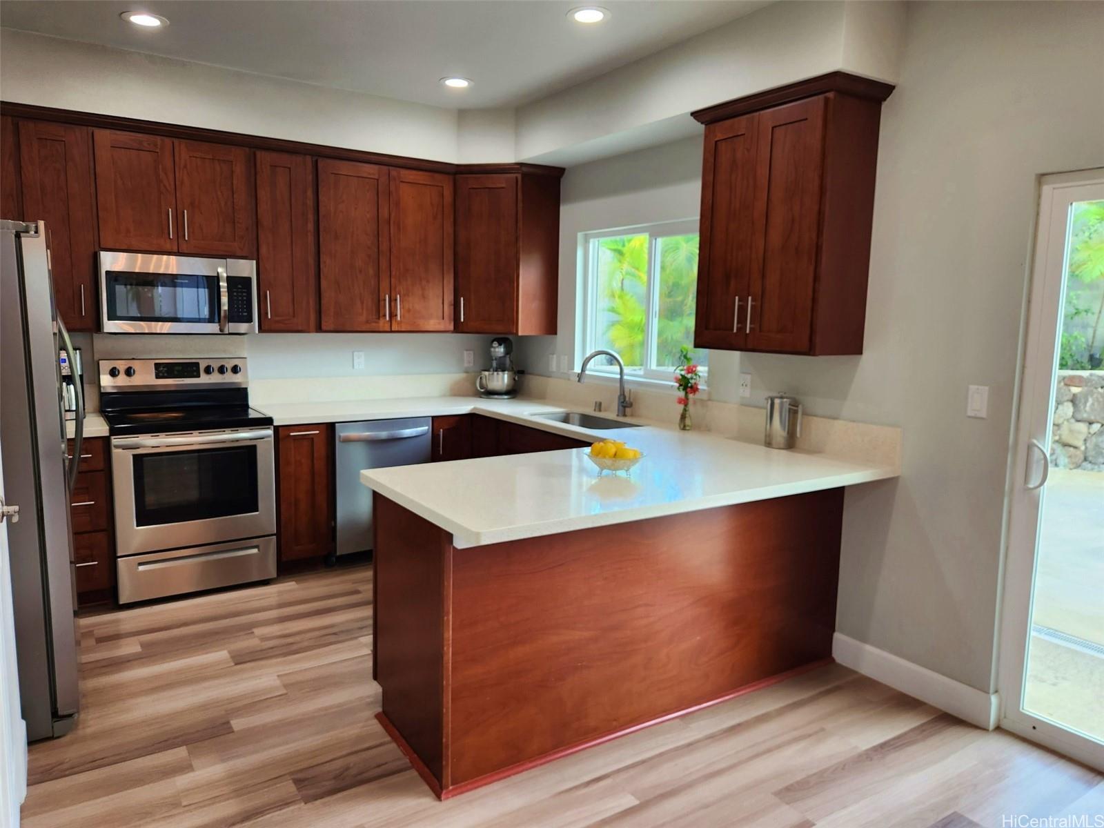 47-285 Waihee Road, Unit D Kaneohe, HI 96744 - Photo 7 of 25 a kitchen with stainless steel appliances granite countertop a sink a stove and a microwave