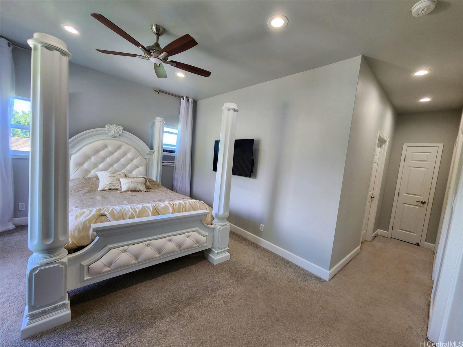 47-285 Waihee Road, Unit D Kaneohe, HI 96744 - Photo 8 of 25 a bedroom with a bed and a large mirror