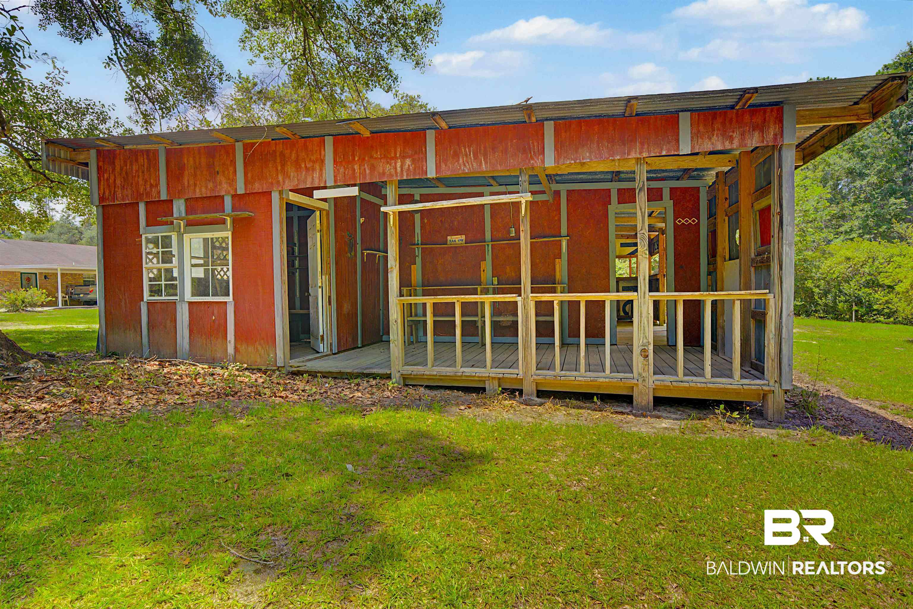 22963 Highway 98 Foley, AL 36535 - Photo 38 of 52 Red-sided accessory structure with an open-air porch, a sloped roof, and visible framing elements