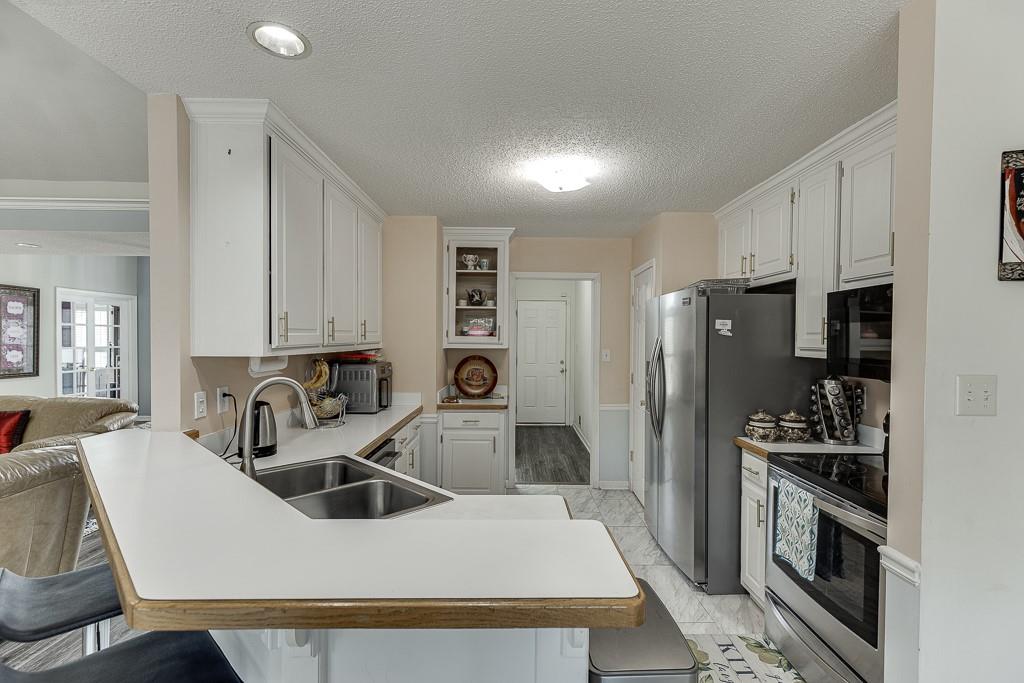 1262 Bowman Road Lawrenceville, GA 30045 - Photo 13 of 32 a kitchen with a sink a stove and refrigerator