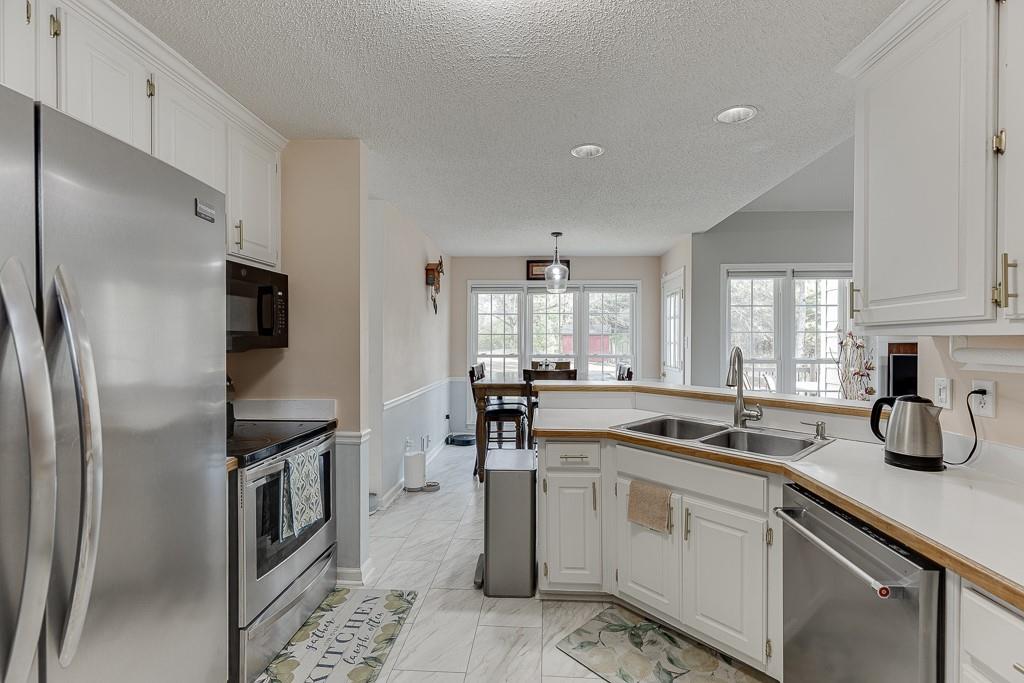 1262 Bowman Road Lawrenceville, GA 30045 - Photo 16 of 32 a kitchen with white cabinets and stainless steel appliances