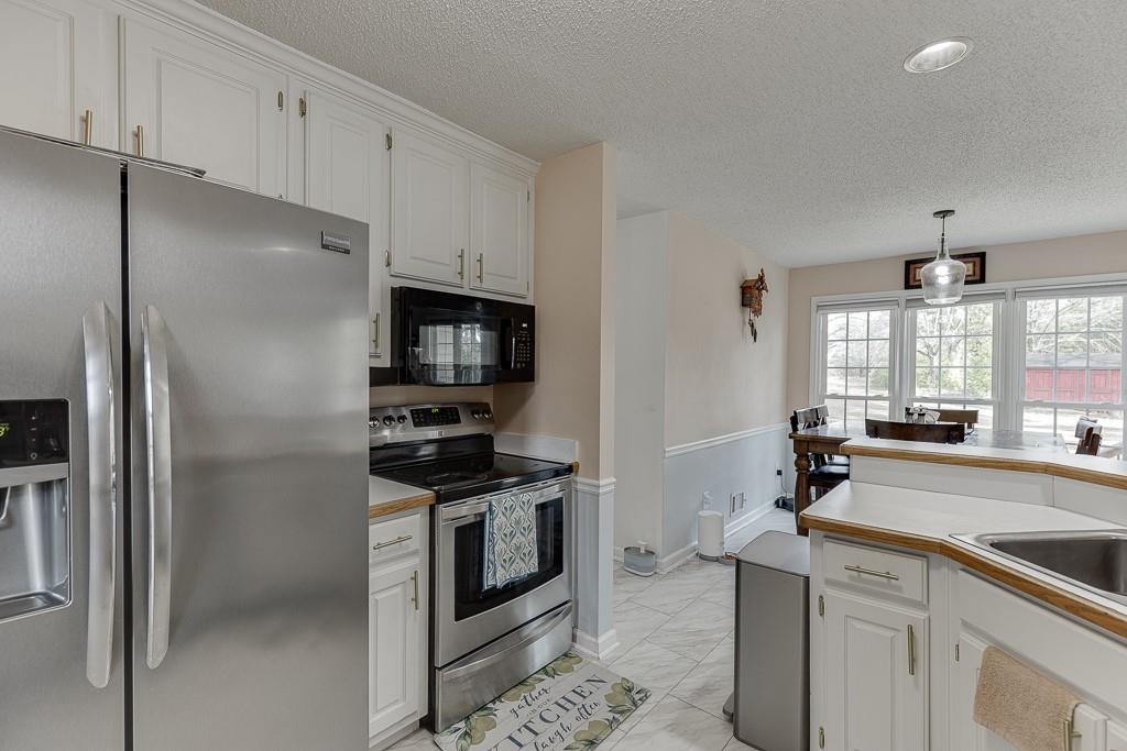 1262 Bowman Road Lawrenceville, GA 30045 - Photo 17 of 32 a kitchen with stainless steel appliances a refrigerator stove and sink
